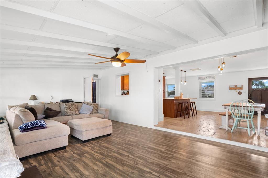 A living room with wood-look flooring and a ceiling fan opens to a dining area — 21748 EDGEWATER DRIVE, PORT CHARLOTTE, FL