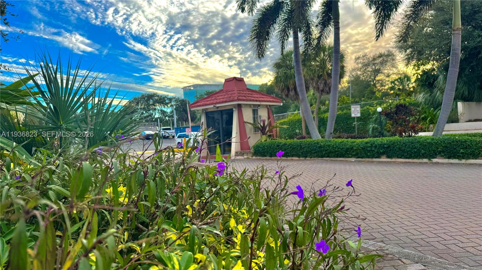 A small guardhouse with a red roof sits at the entrance of a paved driveway — 636 NW 13th St # 0230, Boca Raton FL 33486, BOCA RATON, FL
