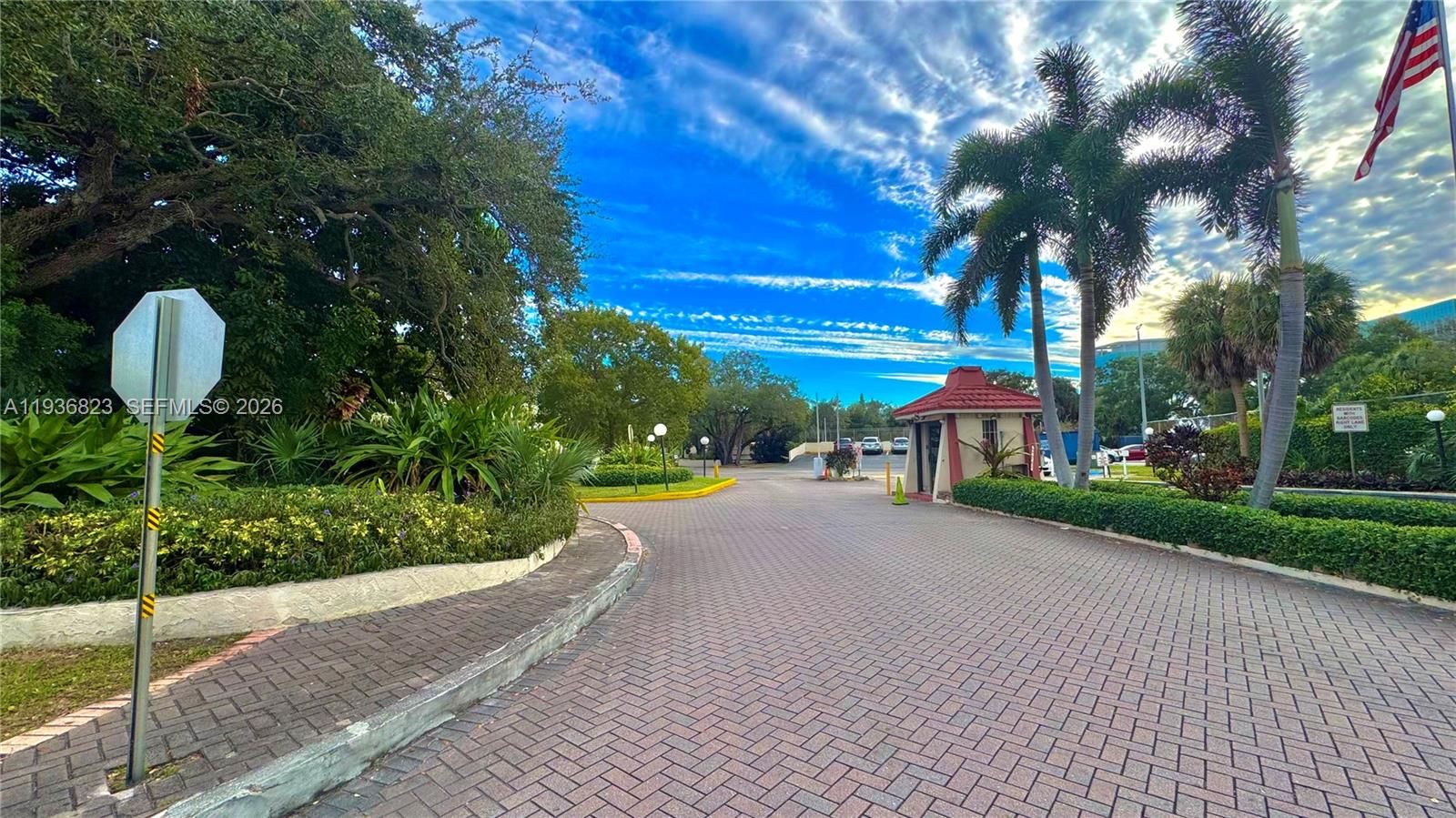 A paved driveway leads to a gated entrance with a small guardhouse and palm trees — 636 NW 13th St # 0230, Boca Raton FL 33486, BOCA RATON, FL