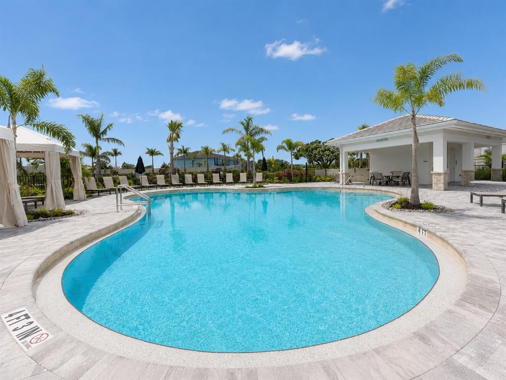 A swimming pool with a surrounding patio, lounge chairs, palm trees, and a covered pavilion — 15144 CUZCORRO COURT, NOKOMIS, FL