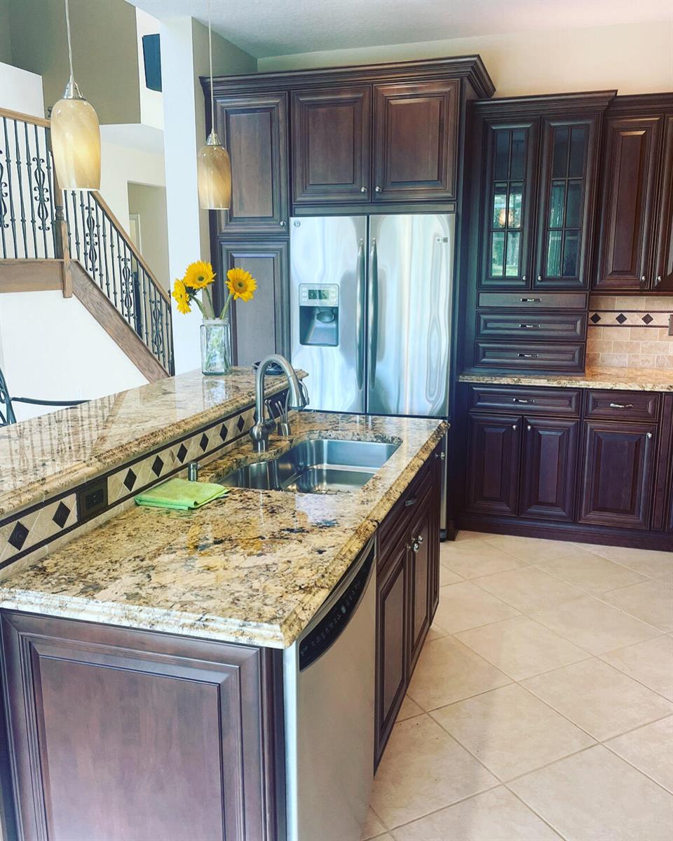 A kitchen featuring dark wood cabinets, granite countertops, stainless steel appliances, and a tile floor — 7754 Monarch Court, Delray Beach FL 33446, DELRAY BEACH, FL