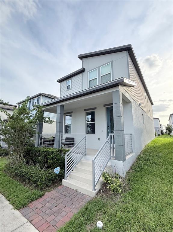 A two-story house features a front porch with metal railings and a brick walkway — 4958 CITRUS LEAF BLVD, WINTER GARDEN, FL