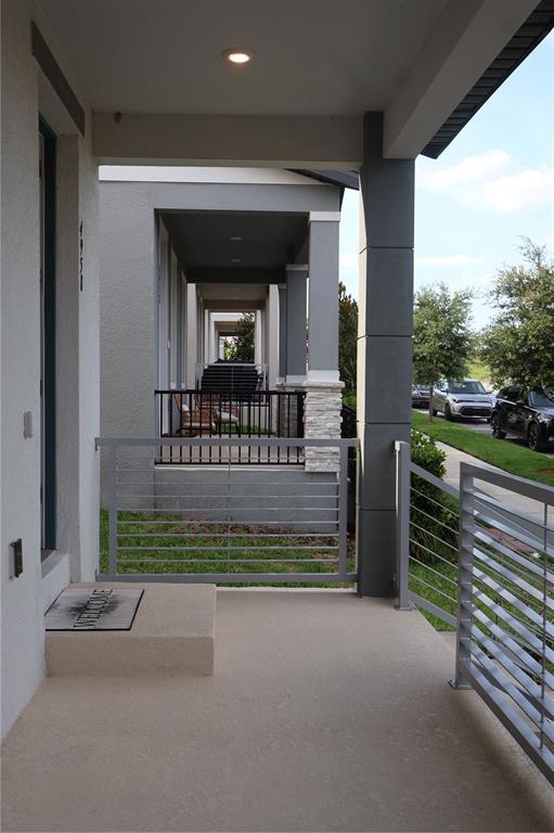 A covered front porch features a concrete floor, metal railings, and a welcome mat — 4958 CITRUS LEAF BLVD, WINTER GARDEN, FL