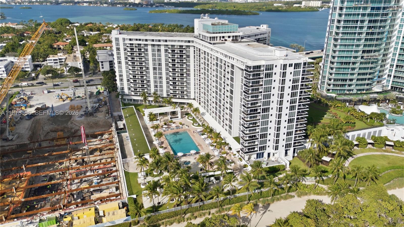 An aerial view shows a large white apartment building with a pool and construction site — 10275 Collins Avenue # 1101, Bal Harbour FL 33154, BAL HARBOUR, FL