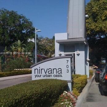 A sign for a residential complex stands at the entrance gate next to a road — 750 NE 64th St # B215, Miami FL 33138, MIAMI, FL
