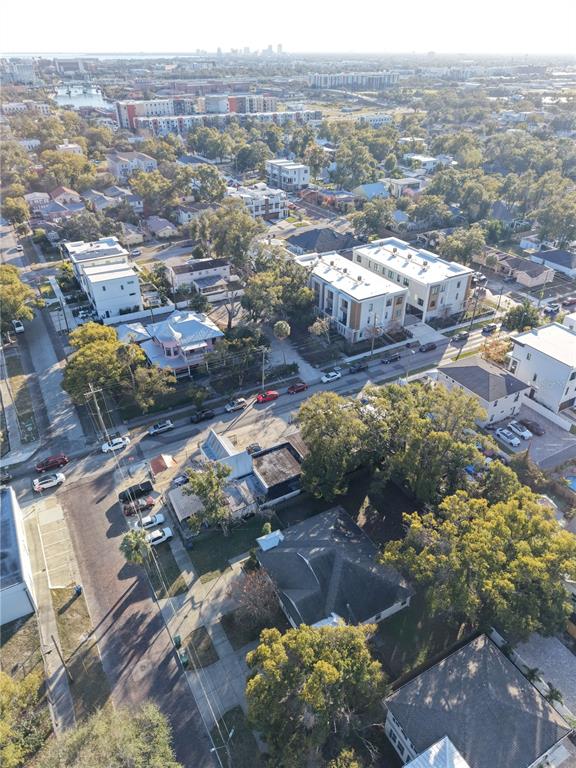 An aerial view shows a residential neighborhood with houses, apartment buildings, and tree-lined streets — 201 W COLUMBUS DRIVE, TAMPA, FL