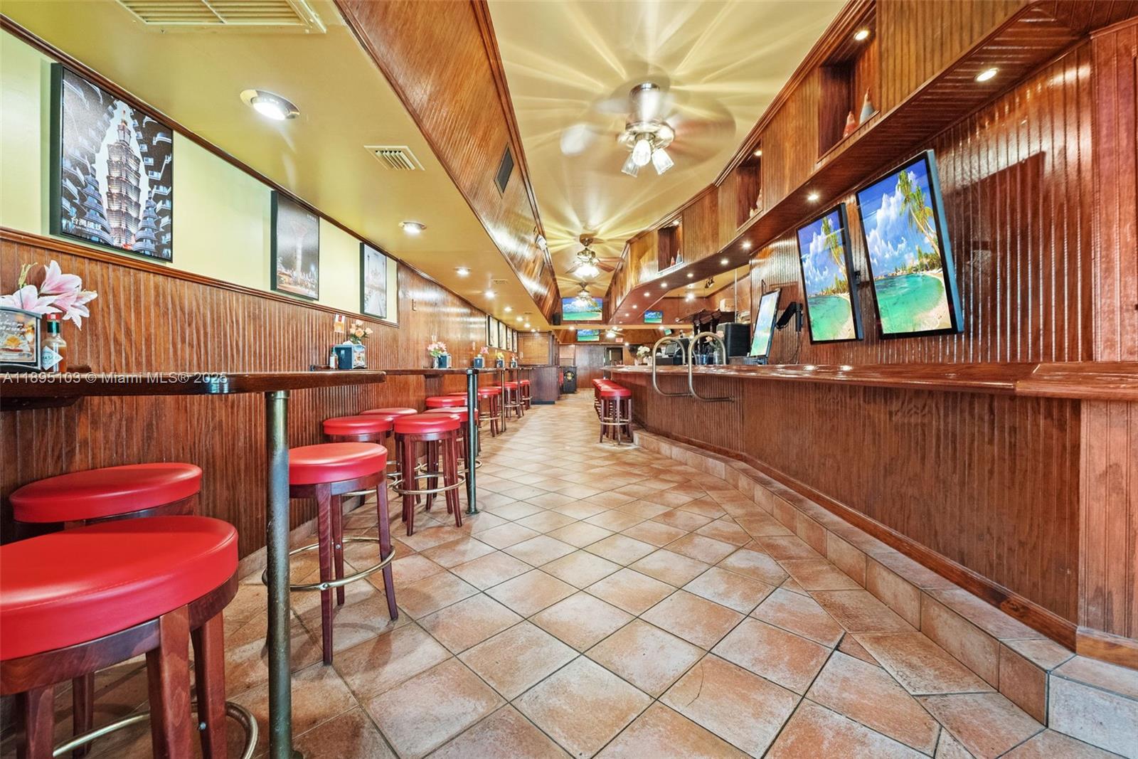 A long bar area features wood-paneled walls, red stools, and tiled flooring — 6330 Miramar Pkwy, Miramar FL 33023, MIRAMAR, FL