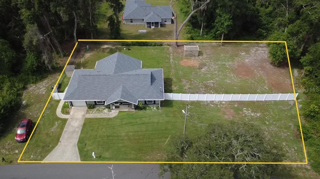 An aerial view shows a house with a gray roof, a driveway, and a fenced yard — 10 EMERALD TRAIL, OCALA, FL