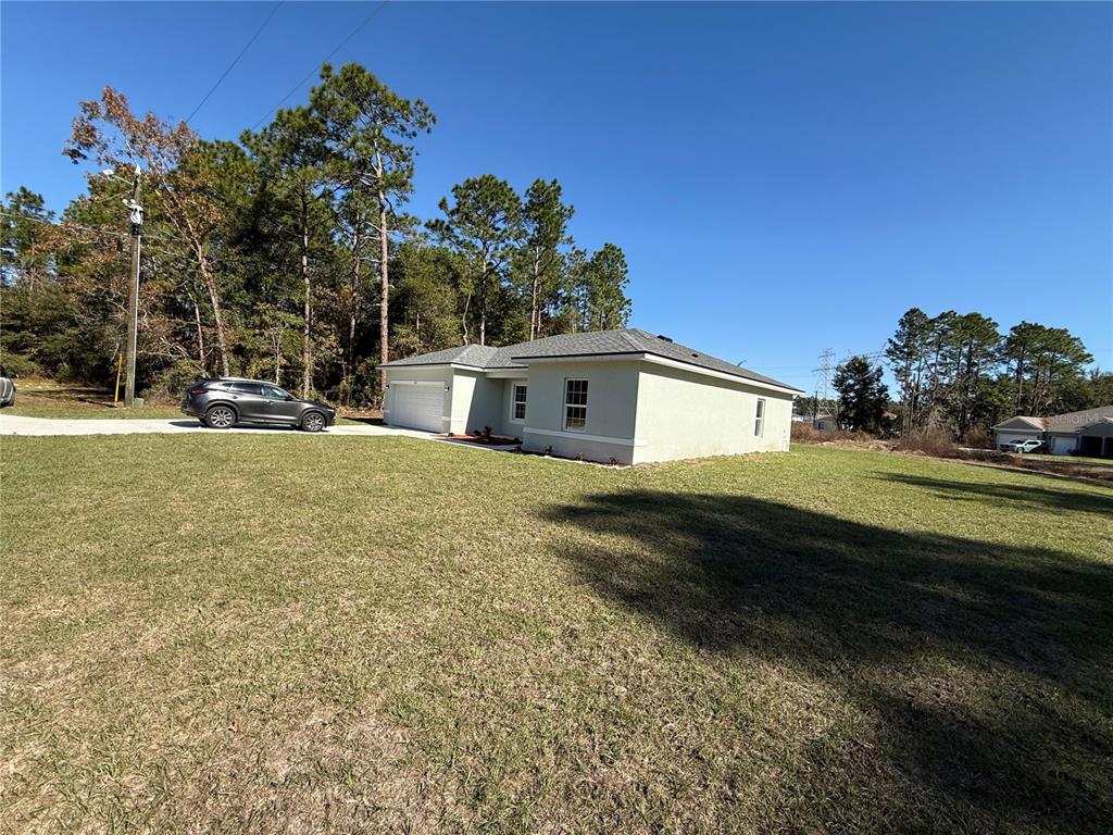 A single-story house with a light-colored exterior and a gray roof sits on a lawn — 6365 SW 156TH STREET, OCALA, FL