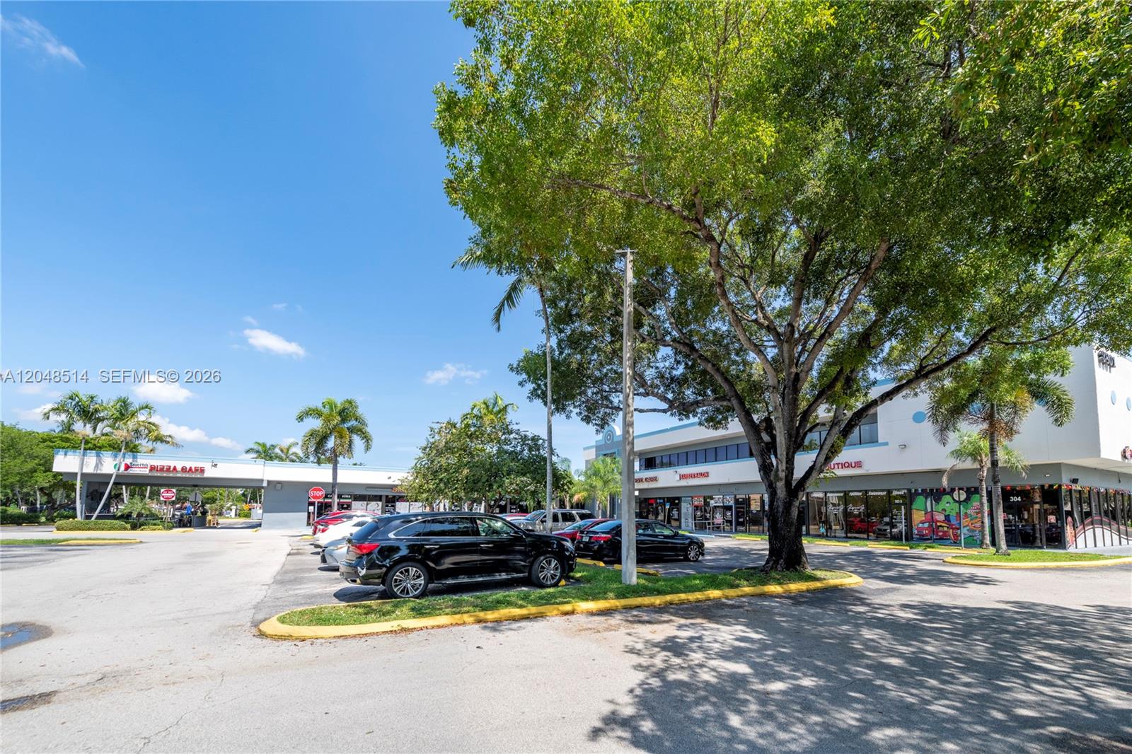 A parking lot sits in front of a commercial strip mall with trees and cars — 3801 N University Dr # 313, Sunrise FL 33351, SUNRISE, FL