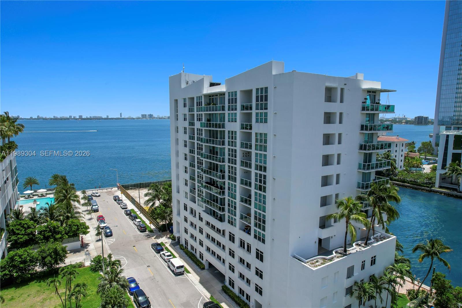 An aerial view shows a white multi-story residential building situated beside a bay — 500 NE 29th St # 608, Miami FL 33137, MIAMI, FL