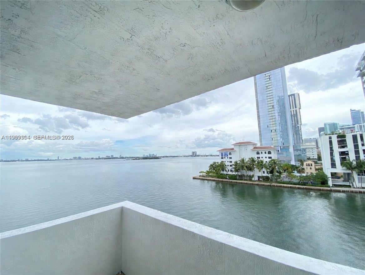 A balcony overlooks a bay with a view of nearby high-rise buildings and palm trees — 500 NE 29th St # 608, Miami FL 33137, MIAMI, FL