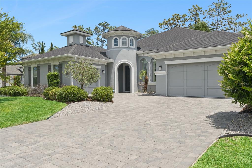 A gray single-story house with a circular turret entrance and a paved driveway — 2423 WILD TURKEY CREEK LANE, PORT ORANGE, FL