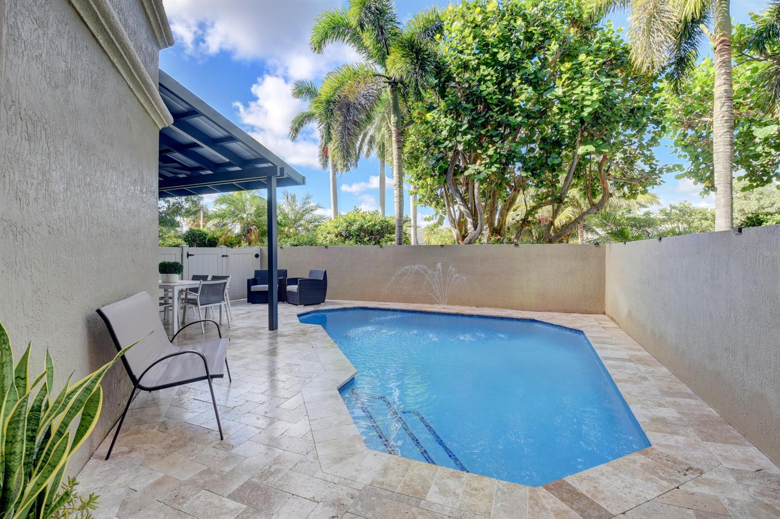 A patio with a swimming pool, fountain, and outdoor seating area under a covered roof — 921 Osceola Drive Unit 4, Boca Raton FL 33432, BOCA RATON, FL