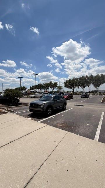 A gray SUV is parked in a paved parking lot under a bright, cloudy sky — 42601 HIGHWAY 27, DAVENPORT, FL