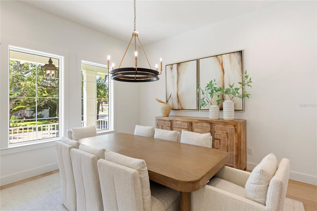 A dining room features a wooden table, upholstered chairs, a sideboard, and a chandelier — 4311 W SEVILLA STREET, TAMPA, FL