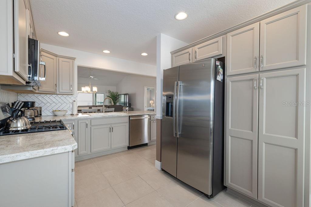 A kitchen with light gray cabinets, stainless steel appliances, and light-colored countertops — 2454 YOUNGMANN LOOP, THE VILLAGES, FL