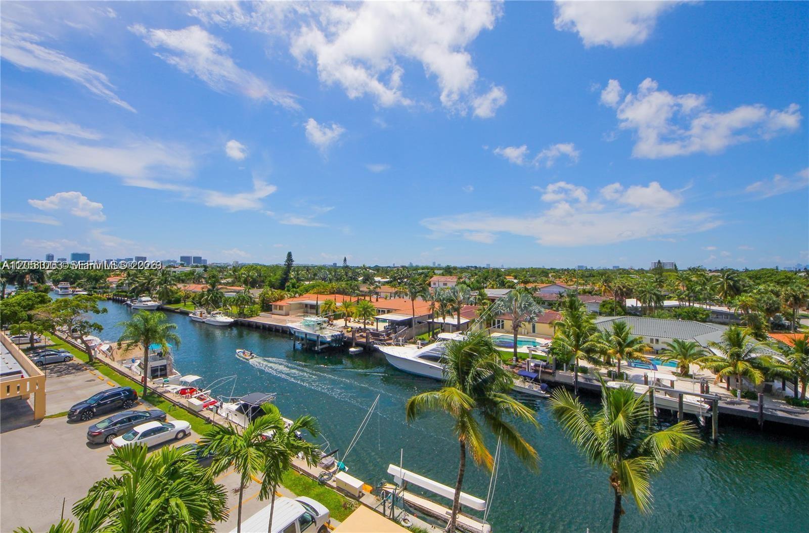 An elevated view of a canal lined with houses, palm trees, and docked boats — 2350 NE 135th St # 403, North Miami FL 33181, NORTH MIAMI, FL
