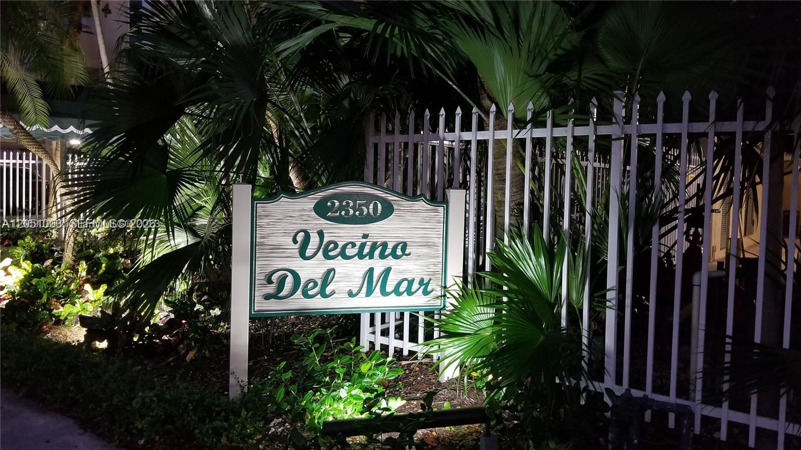 A sign for Vecino Del Mar stands in front of a white metal fence — 2350 NE 135th St # 403, North Miami FL 33181, NORTH MIAMI, FL