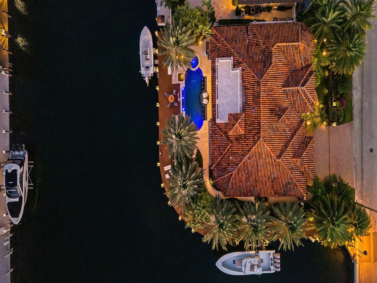 An aerial view of a waterfront home featuring a tiled roof, pool, and docked boats — 2319 NE 28th Street, Lighthouse Point FL 33064, LIGHTHOUSE POINT, FL