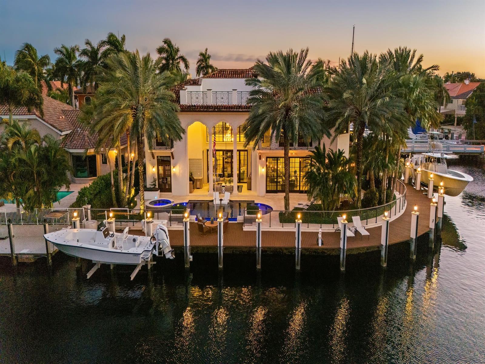 An aerial view of a waterfront mansion with a pool, dock, and two boats — 2319 NE 28th Street, Lighthouse Point FL 33064, LIGHTHOUSE POINT, FL