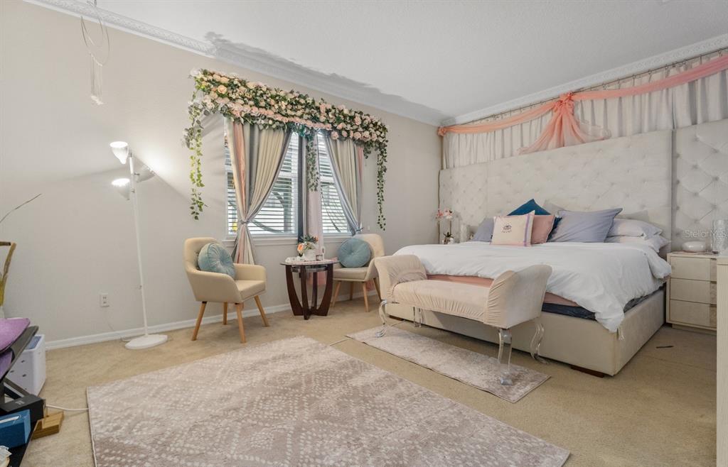 A bedroom features a tufted headboard, floral window decor, two chairs, and a bench — 2987 BOATING BOULEVARD, KISSIMMEE, FL
