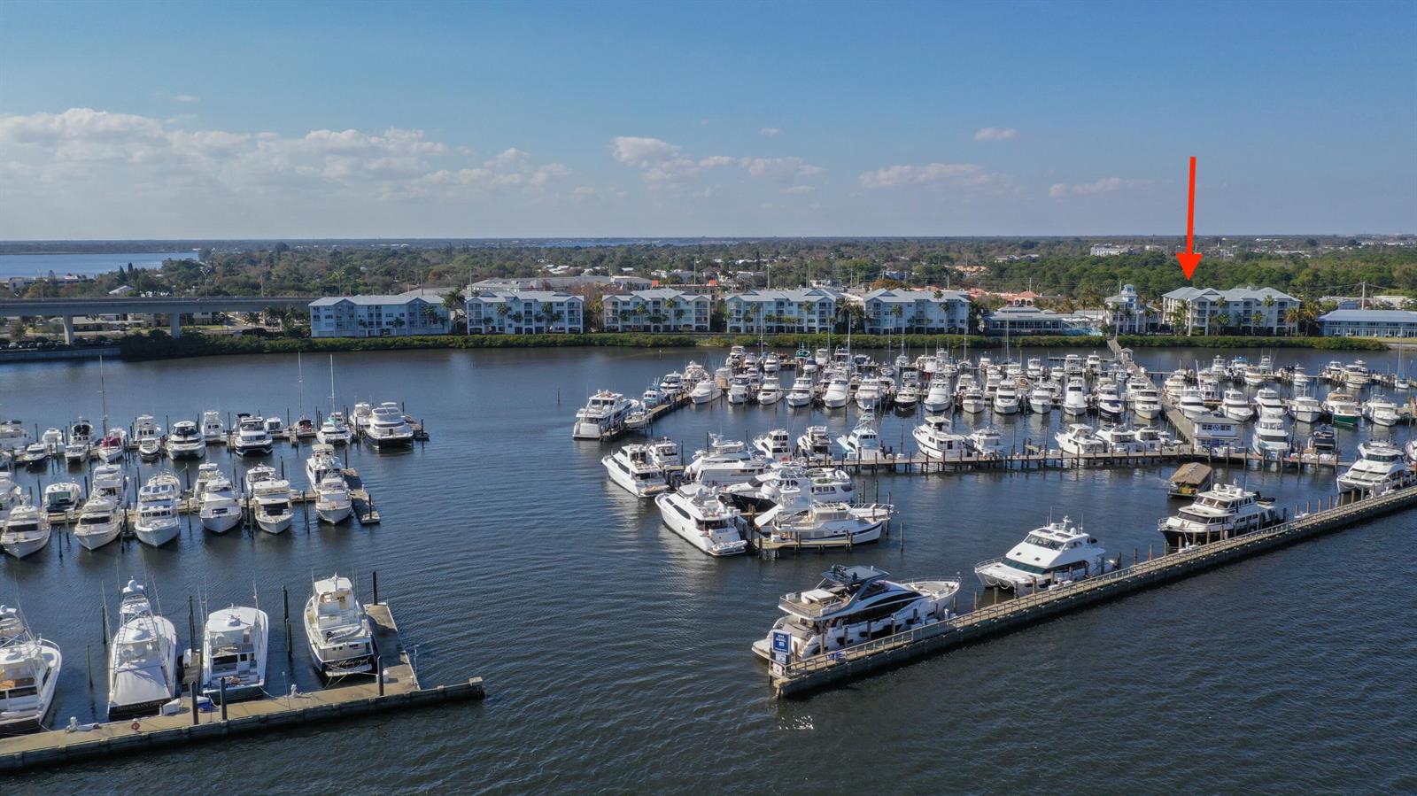 An aerial view shows a marina filled with numerous boats in front of waterfront apartment buildings — 975 NW Flagler Avenue # 206, Stuart FL 34994, STUART, FL