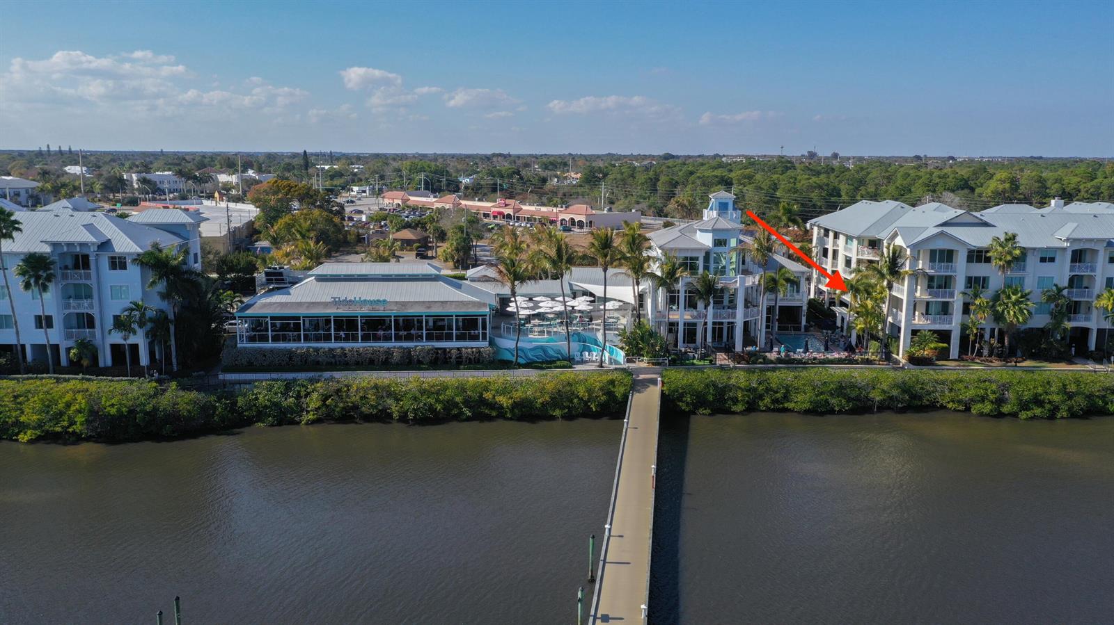 An aerial view shows a waterfront restaurant and adjacent multi-story residential buildings with a pier — 975 NW Flagler Avenue # 206, Stuart FL 34994, STUART, FL