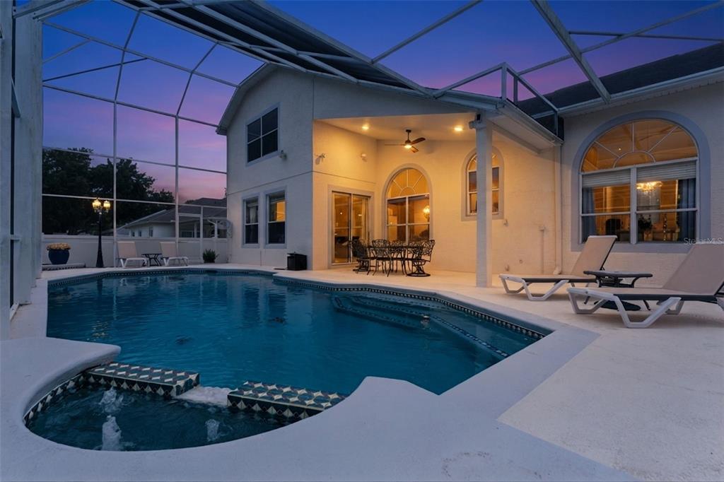 A swimming pool and spa sit on a patio enclosed by a screened-in lanai — 8355 DIAMOND COVE CIRCLE, ORLANDO, FL
