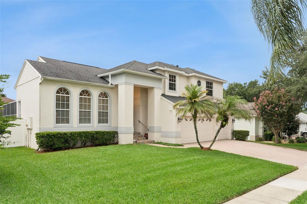A two-story stucco house with a shingled roof, arched windows, and a paved driveway — 8355 DIAMOND COVE CIRCLE, ORLANDO, FL