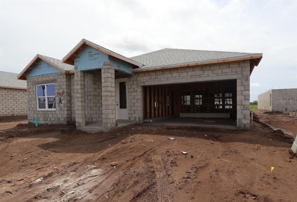 An exterior view of a single-story house under construction with concrete block walls and shingles — 5257 COLONY VISTA DRIVE, APOLLO BEACH, FL