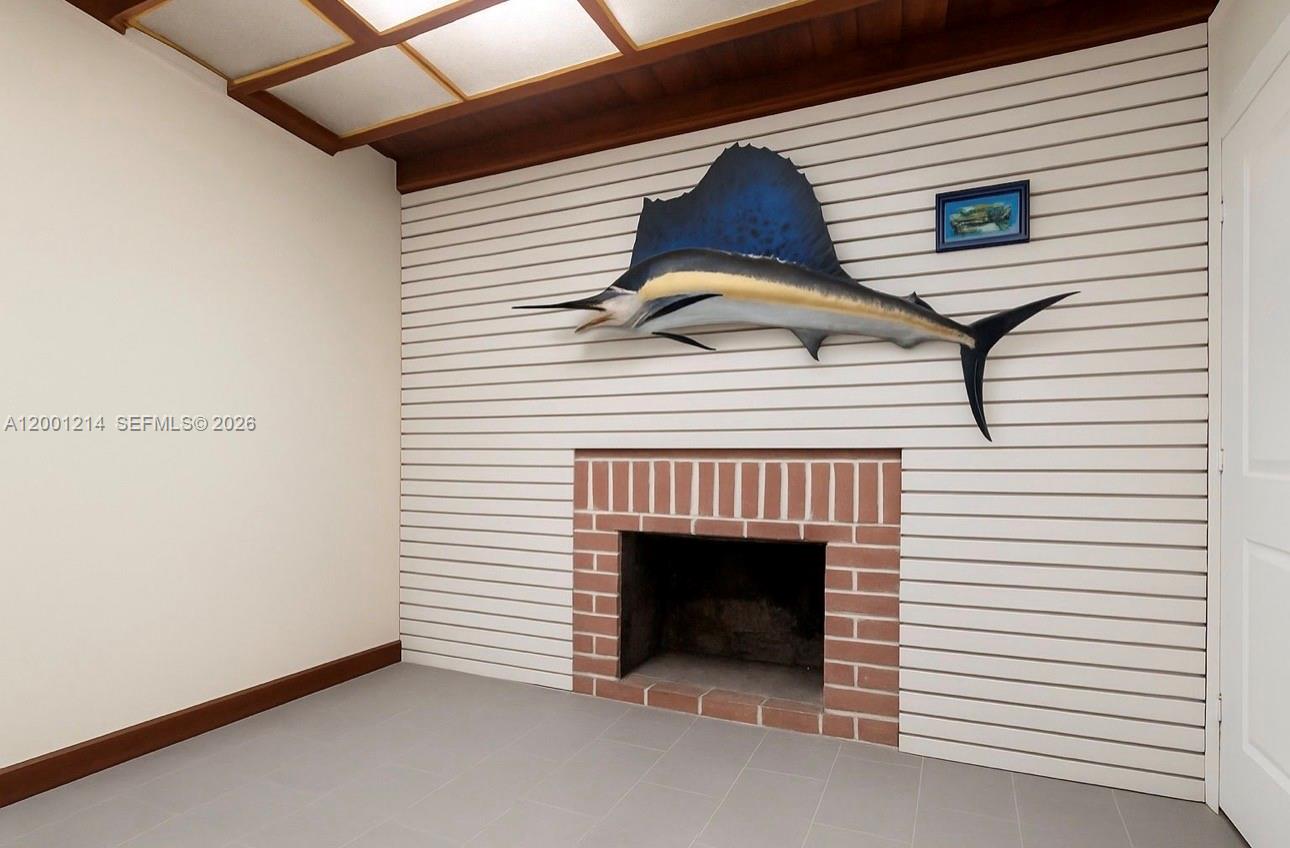 A room features a brick fireplace, a mounted sailfish, and horizontal wall paneling — 101875 Overseas Hwy, Key Largo FL 33037, KEY LARGO, FL