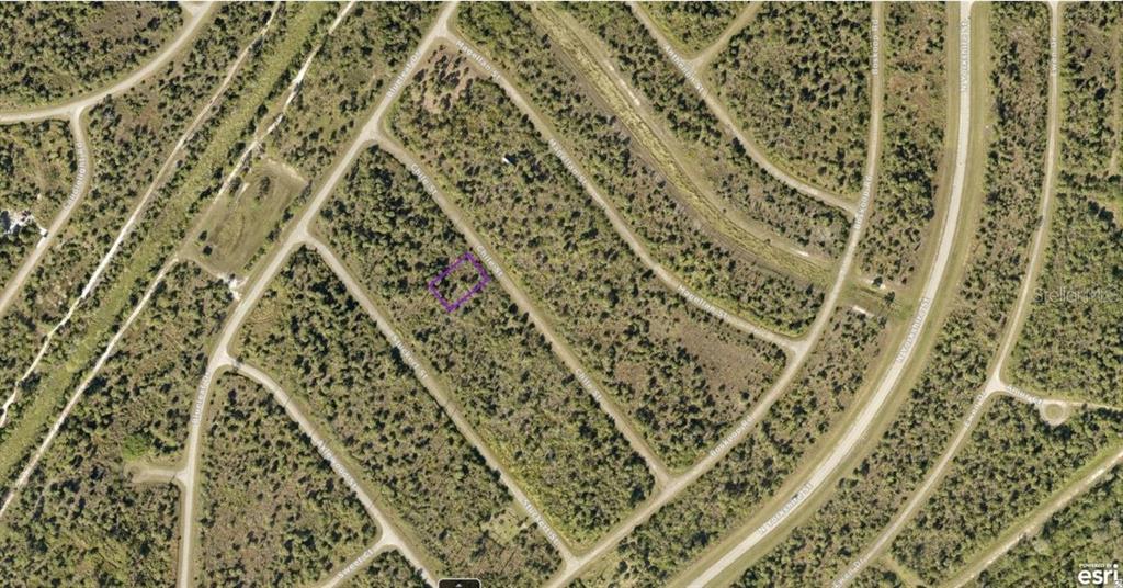 This is an aerial map view of a vacant, wooded residential lot outlined in purple — 1130220018 CHILE STREET, NORTH PORT, FL