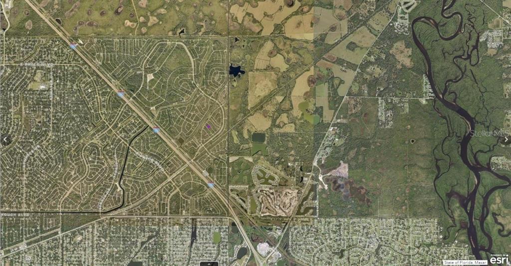 This aerial map shows a residential neighborhood divided by a highway near a river — 1130220018 CHILE STREET, NORTH PORT, FL