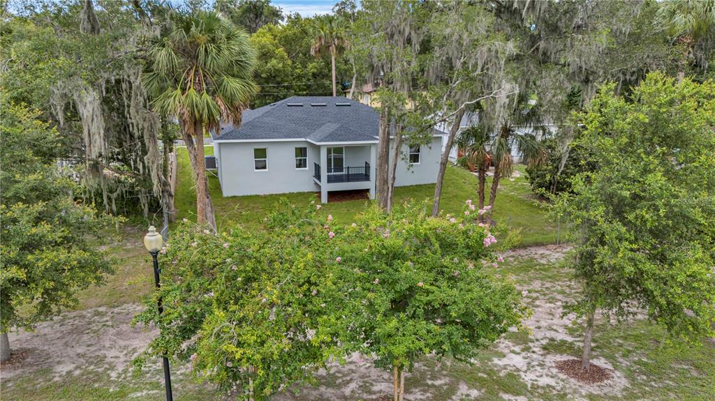 An aerial view of a gray single-story house with a dark roof and back deck — 379 S ORANGE AVENUE, ORANGE CITY, FL
