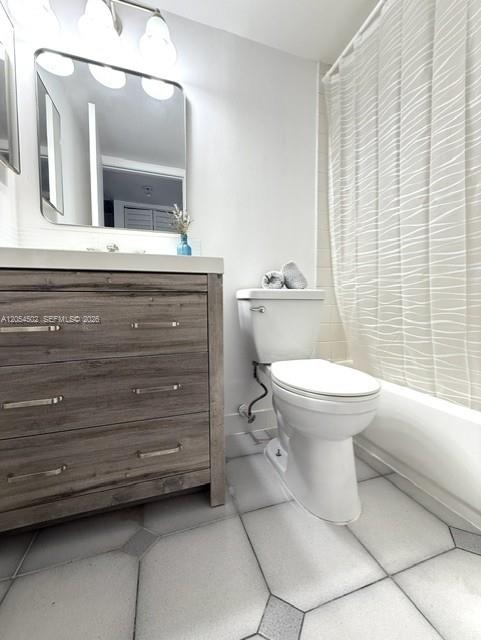 A bathroom features a wooden vanity, a rectangular mirror, and a white toilet — 871 NE 207th Ter # 102, Miami FL 33179, MIAMI, FL