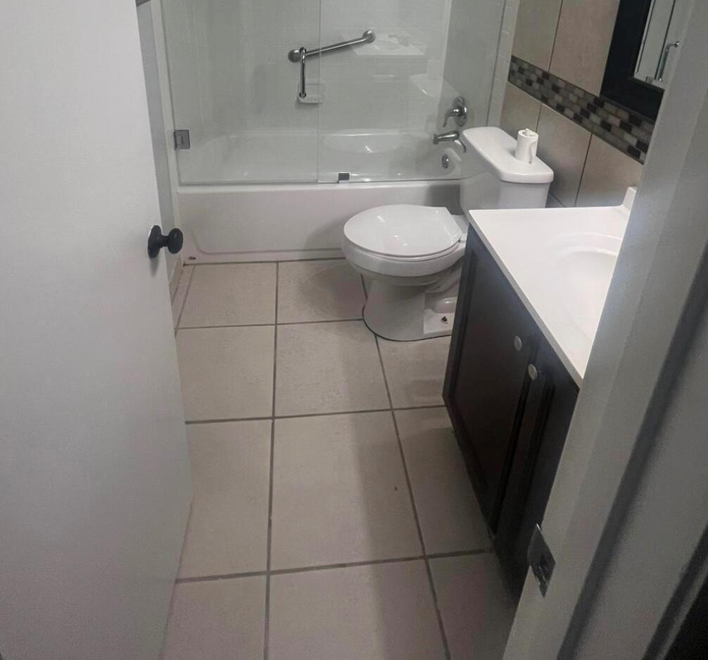 A small bathroom features a white toilet, a dark vanity, and a shower-tub combination — 4815 Sable Pine Circle # C1, West Palm Beach FL 33417, WEST PALM BEACH, FL