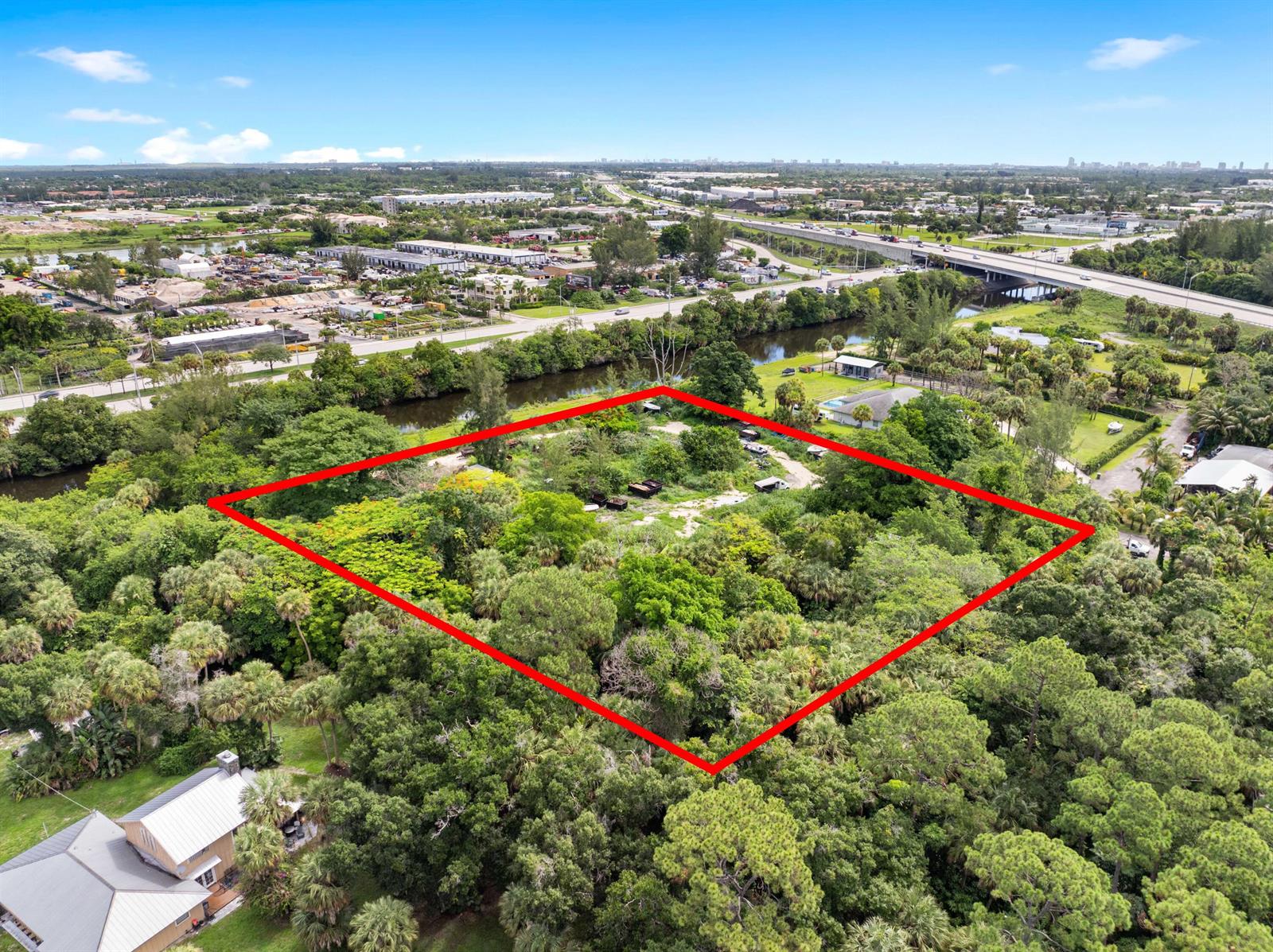 An aerial view shows a rectangular plot of land outlined in red amidst dense vegetation — 69 Armadillo Way, West Palm Beach FL 33411, WEST PALM BEACH, FL