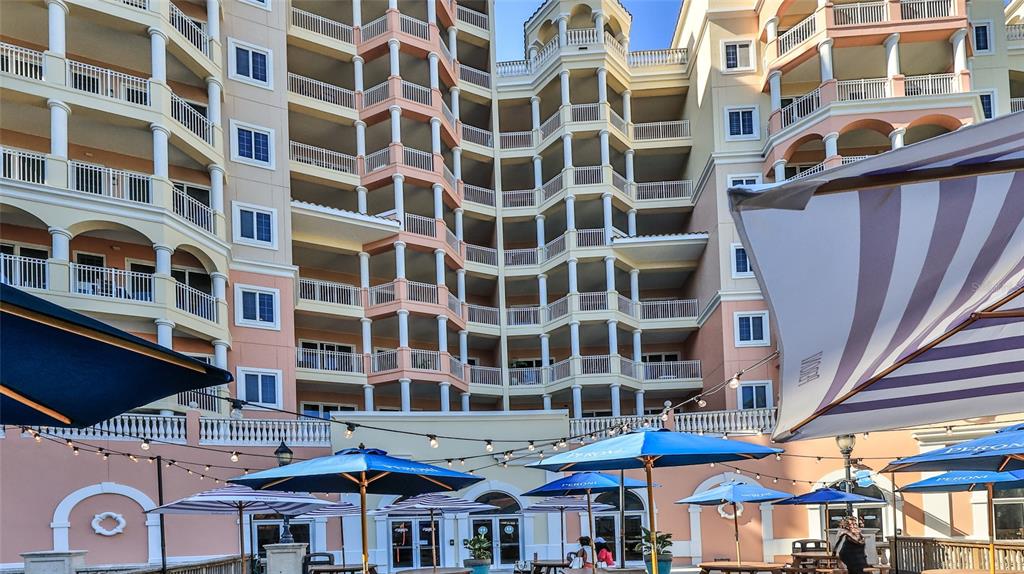 A multi-story resort building features balconies, white columns, and a pool deck with umbrellas — 200 OCEAN CREST DRIVE UNIT 524, PALM COAST, FL