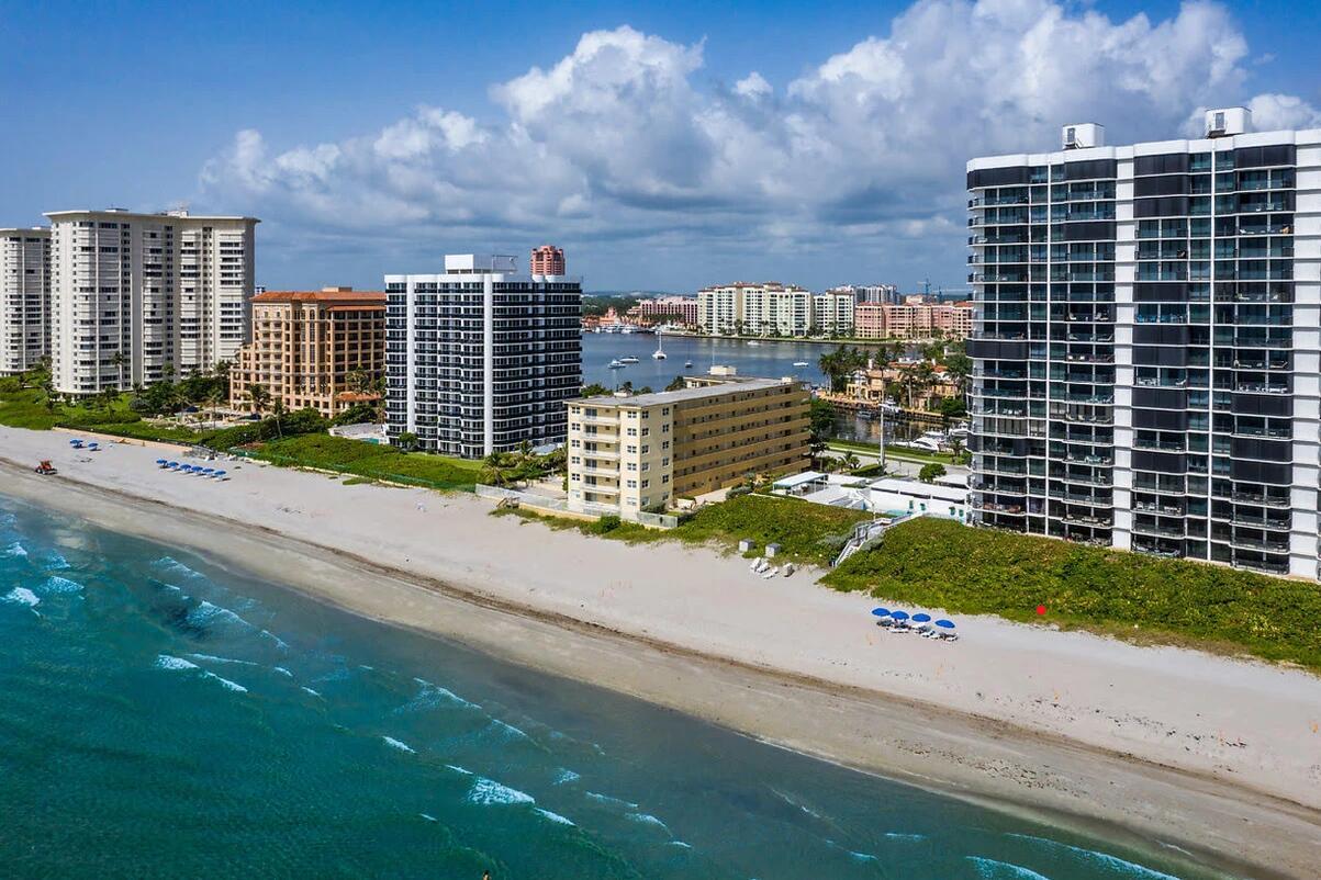 An aerial view of a sandy beach lined with high-rise apartment buildings and coastal vegetation — 310 S Ocean Boulevard # 305, Boca Raton FL 33432, BOCA RATON, FL