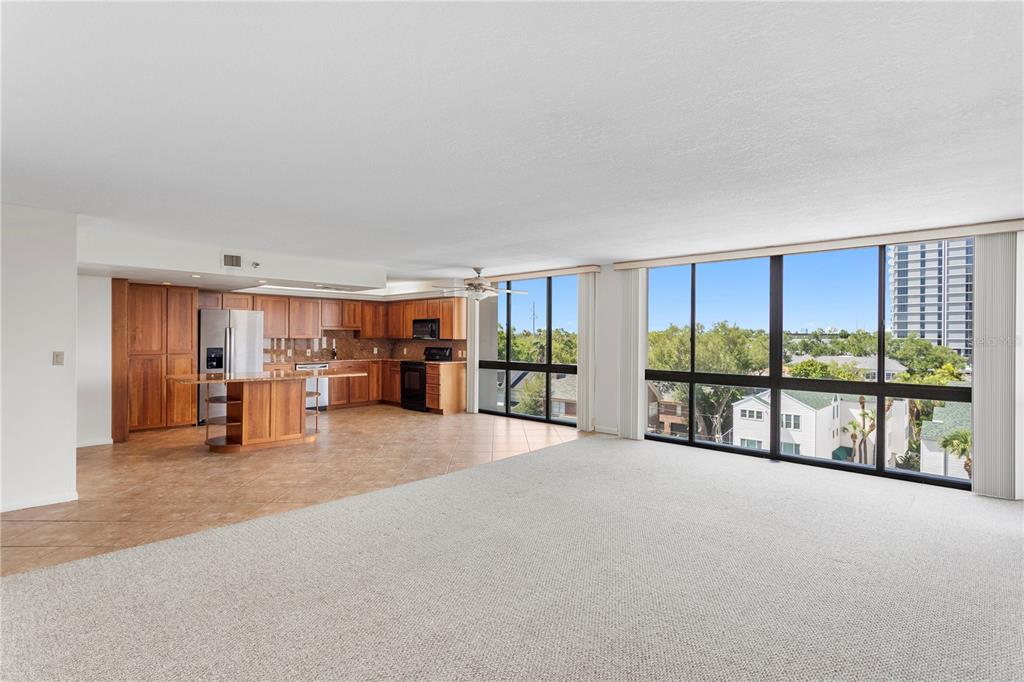 A spacious open-concept living area features a kitchen with wood cabinets and floor-to-ceiling windows — 3301 BAYSHORE BOULEVARD UNIT 702E, TAMPA, FL