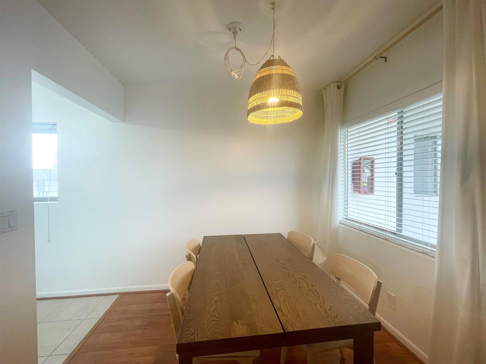 A dining room features a wooden table, four chairs, and a woven pendant light fixture — 2920 Cynthia Lane # 203, FL 33461, FL