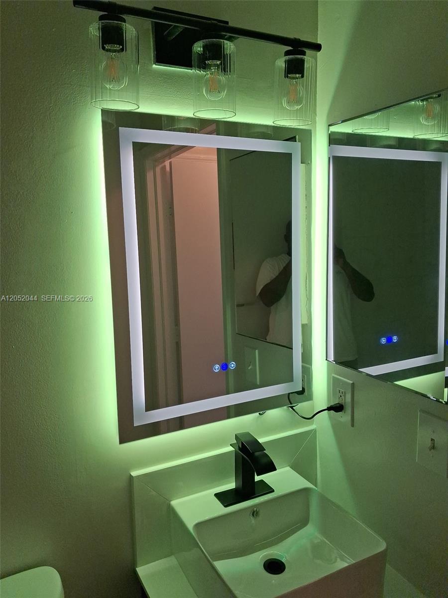 A bathroom features a modern vessel sink, a backlit LED mirror, and a three-light fixture — 7245 NW 173rd Dr # 2502, Hialeah FL 33015, HIALEAH, FL