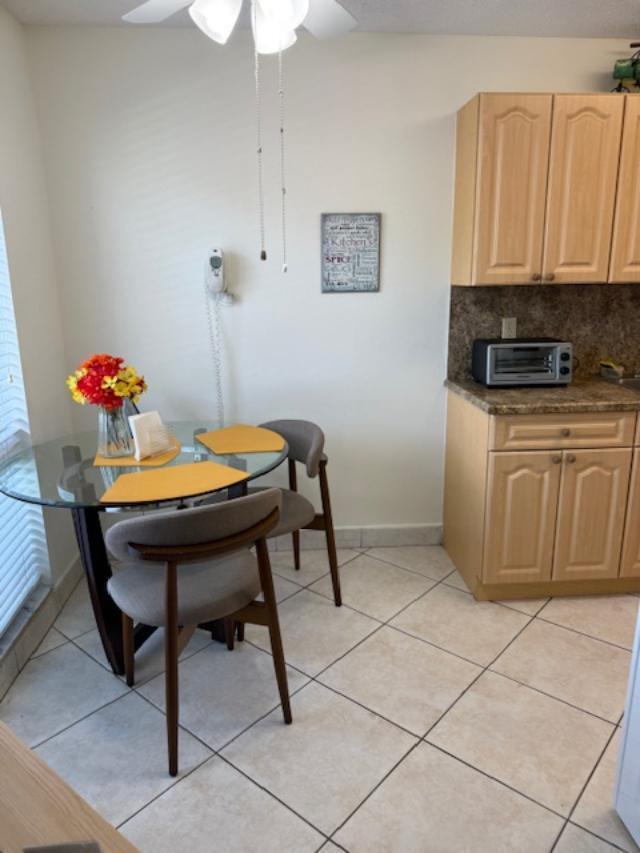A small dining area with a glass table, two chairs, and adjacent kitchen cabinetry — 13678 Vía Flora # B, Delray Beach FL 33484, DELRAY BEACH, FL