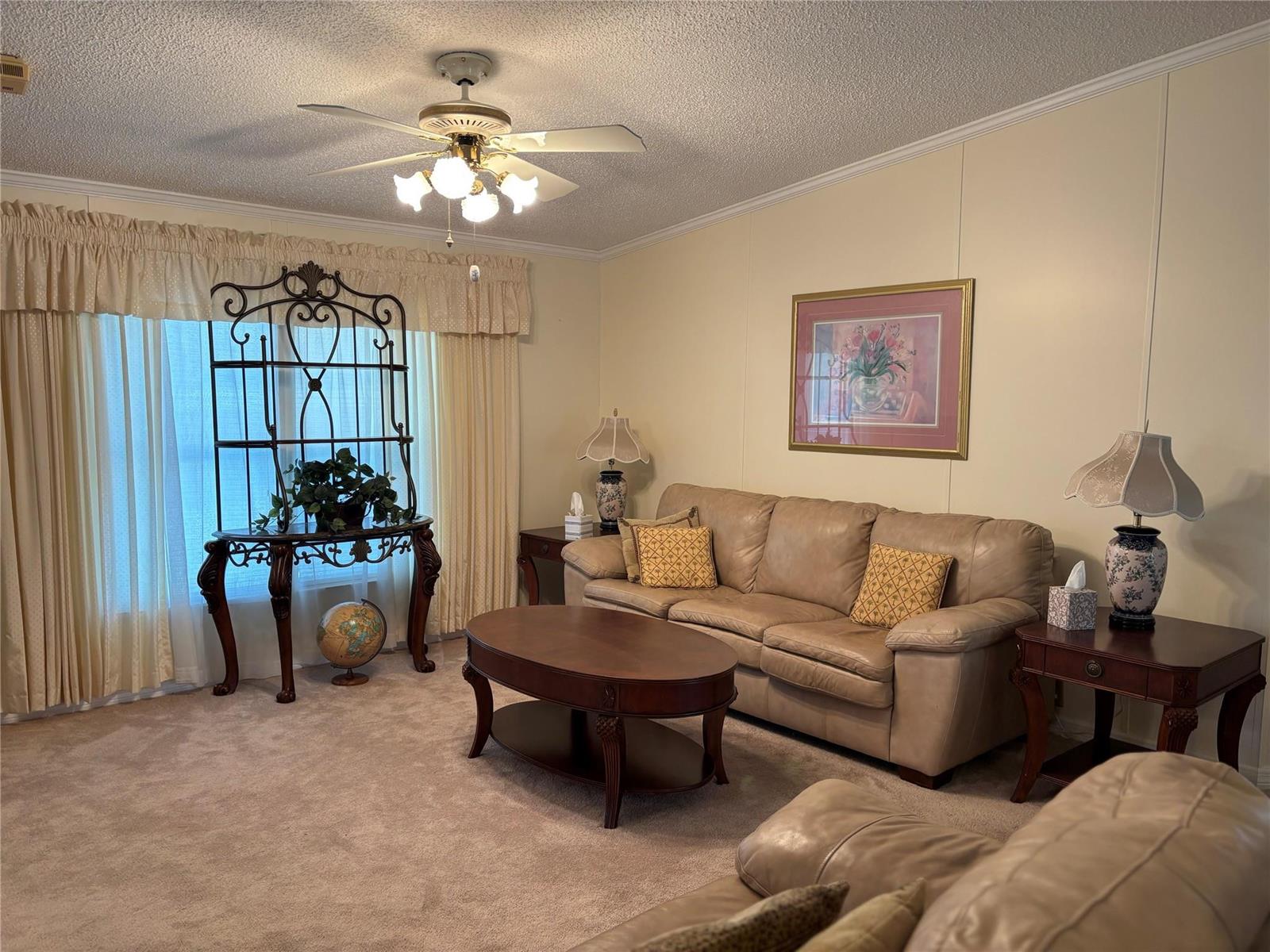 A living room features beige carpet, a leather sofa, a coffee table, and a ceiling fan — 1759 SW 35th Circle, Okeechobee FL 34974, OKEECHOBEE, FL