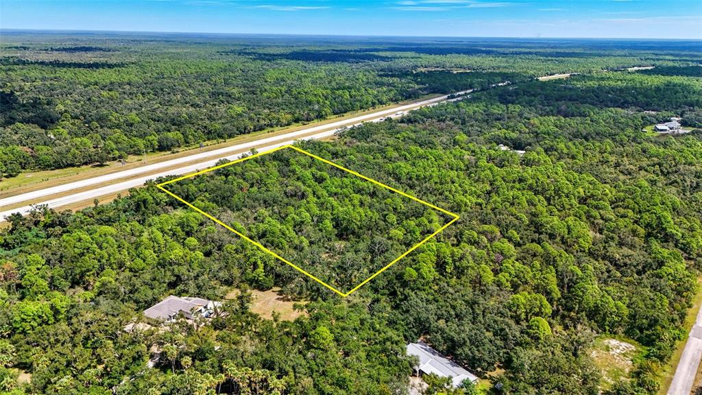 An aerial view shows a rectangular plot of land outlined in yellow amidst dense forest — 0 S MOON DRIVE, VENICE, FL