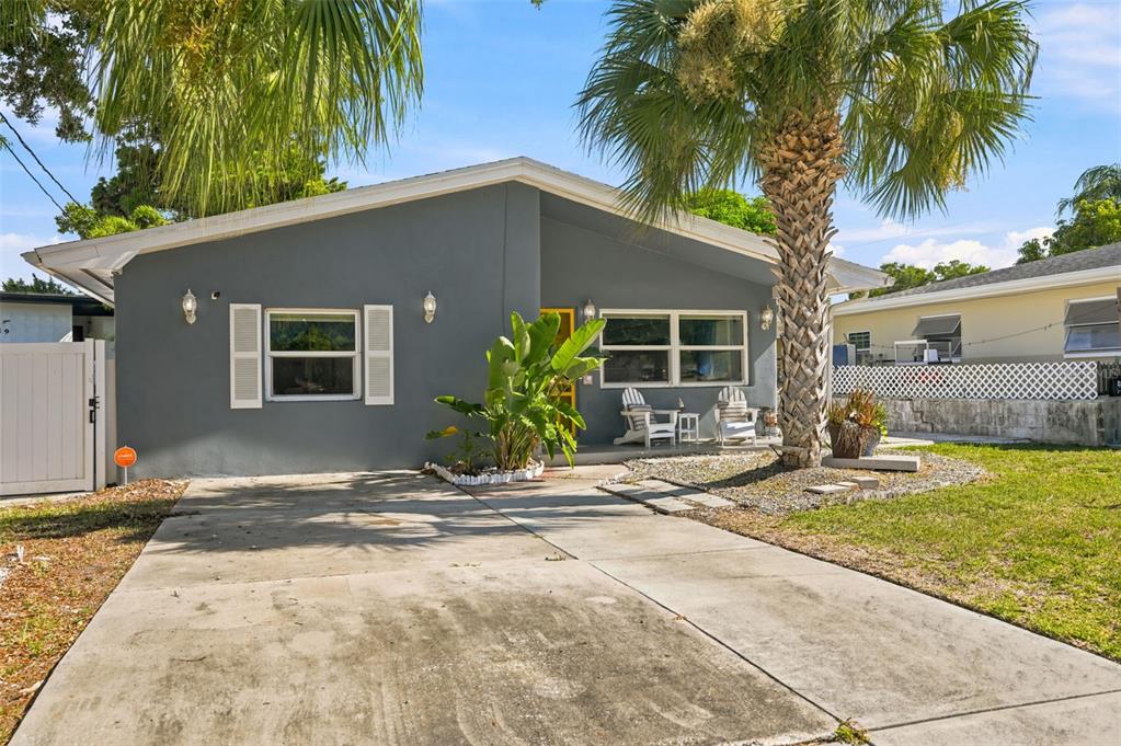 A gray single-story house features a concrete driveway, a palm tree, and white shutters — 1257 FRANKLIN STREET, CLEARWATER, FL