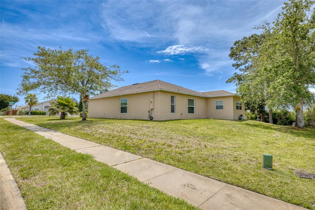 A side view of a tan, single-story house with a lawn and sidewalk — 320 BROKEN OAK DRIVE, EDGEWATER, FL., FL
