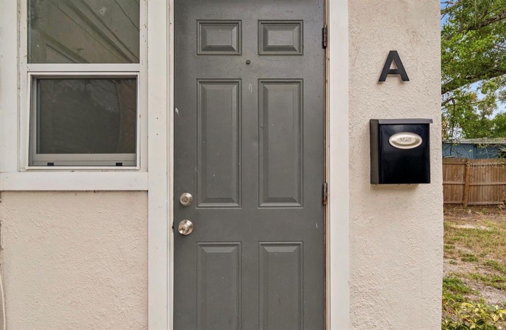 A gray front door with a black mailbox and the letter A on a stucco wall — 725 21ST AVENUE S, ST PETERSBURG, FL