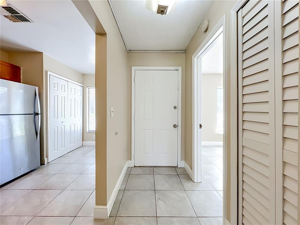 A tiled entryway leads to a white front door, a kitchen area, and a hallway — 2234 STONINGTON AVENUE UNIT 2234, ORLANDO, FL